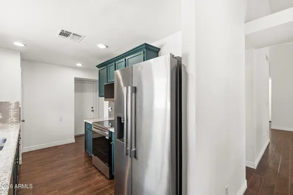 a metallic refrigerator freezer sitting inside of a kitchen