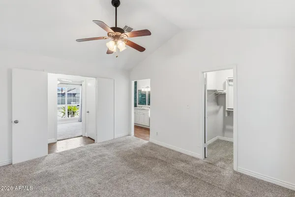 a view of empty room with window and ceiling fan
