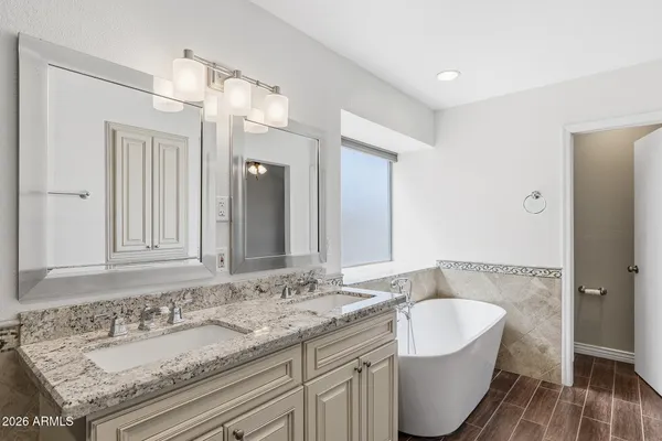 a bathroom with a granite countertop double vanity sink and mirror