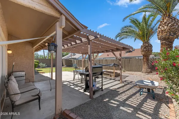 a view of a patio with a table and chairs under an umbrella
