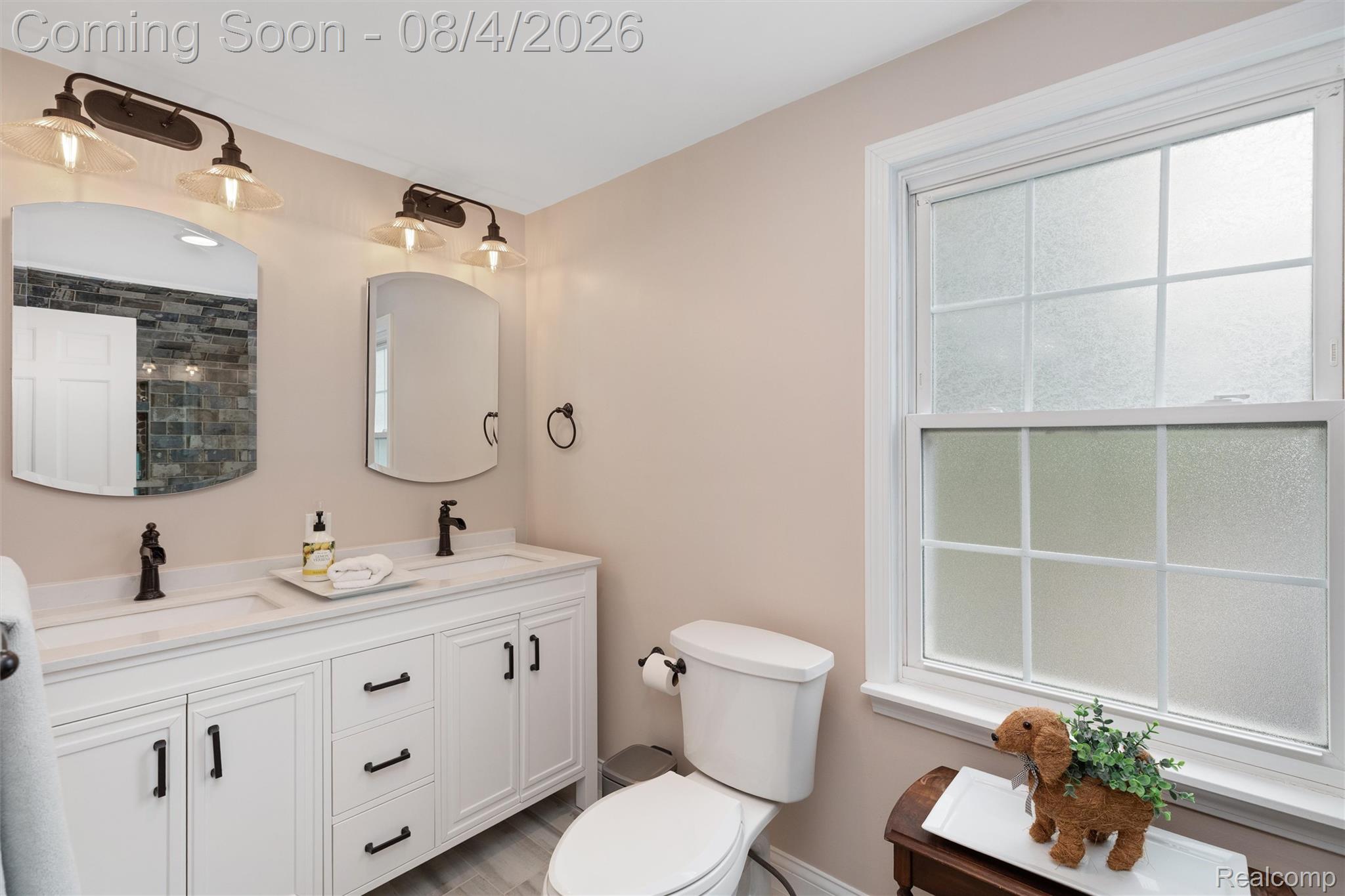 1729 Broadstone Road Grosse Pointe, MI 48236 - Photo 22 of 39 Dual vanity with white cabinetry, matte black hardware, and an integrated countertop