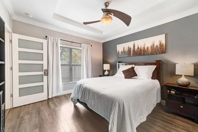 a bedroom with bed and wooden floor