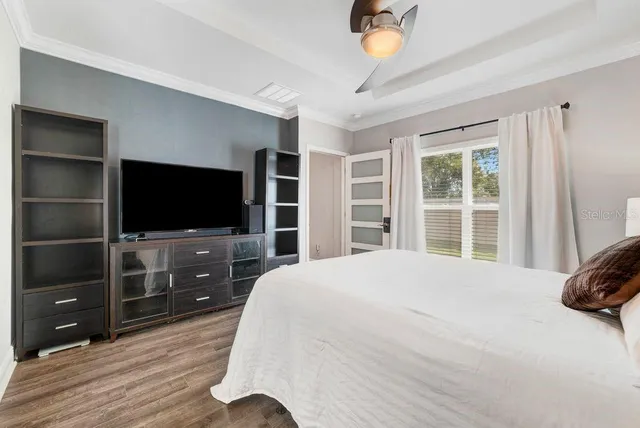 a bedroom with a bed and a flat tv screen on dresser