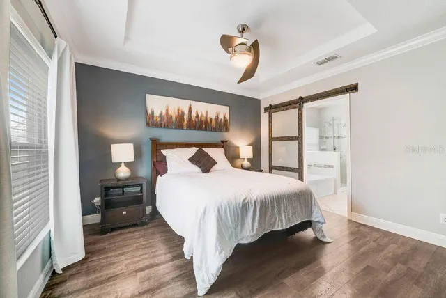 a bedroom with a bed and wooden floor