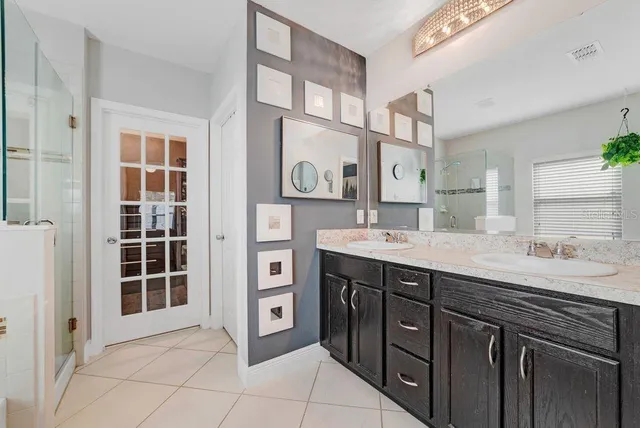 a spacious bathroom with a granite countertop sink a mirror and a shower