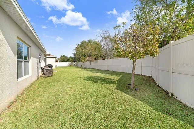 a view of a house with a big yard and potted plants