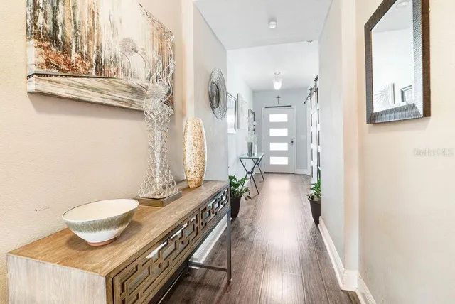 a view of a hallway with furniture and wooden floor