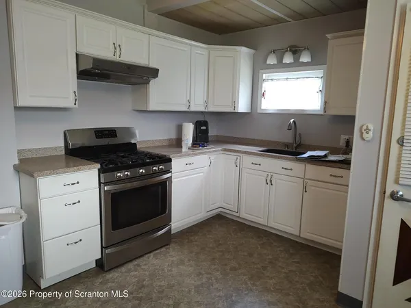a kitchen with granite countertop a sink stove and cabinets