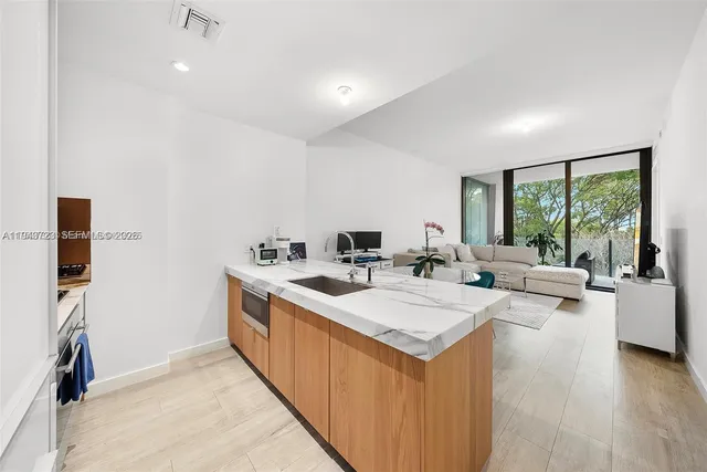 a kitchen with a sink a microwave and cabinets