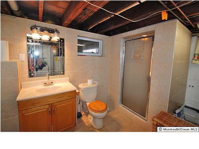 119 Ravine Drive Matawan, NJ 07747 - Photo 11 of 16 a bathroom with a sink a toilet and mirror