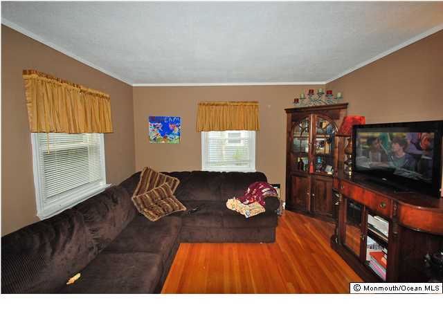 119 Ravine Drive Matawan, NJ 07747 - Photo 6 of 16 a living room with furniture and a flat screen tv
