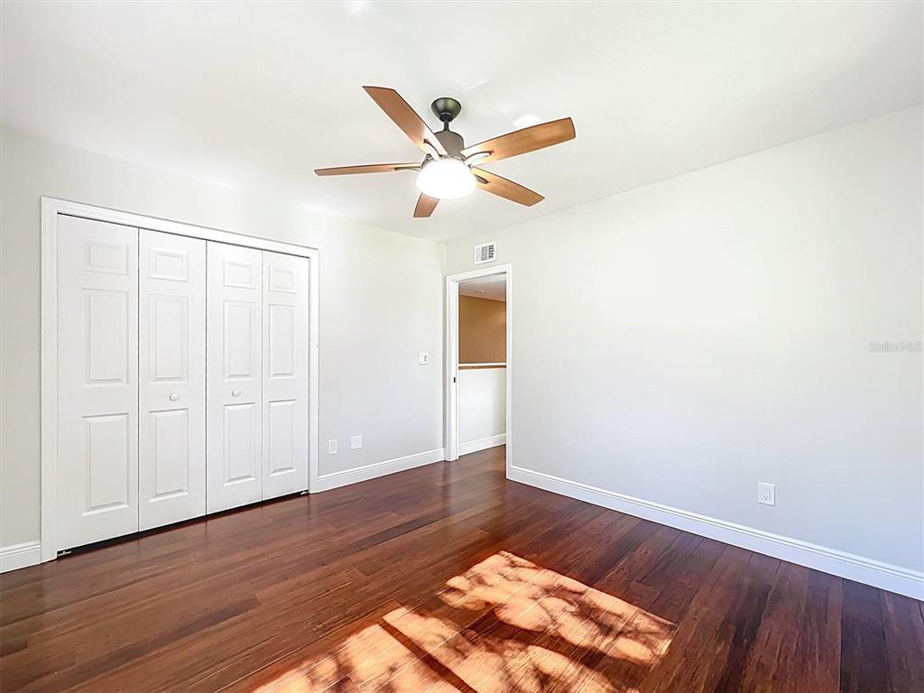 9736 Indian Key Trail, Unit 111 Seminole, FL 33776 - Photo 15 of 56 an empty room with wooden floor fan and windows