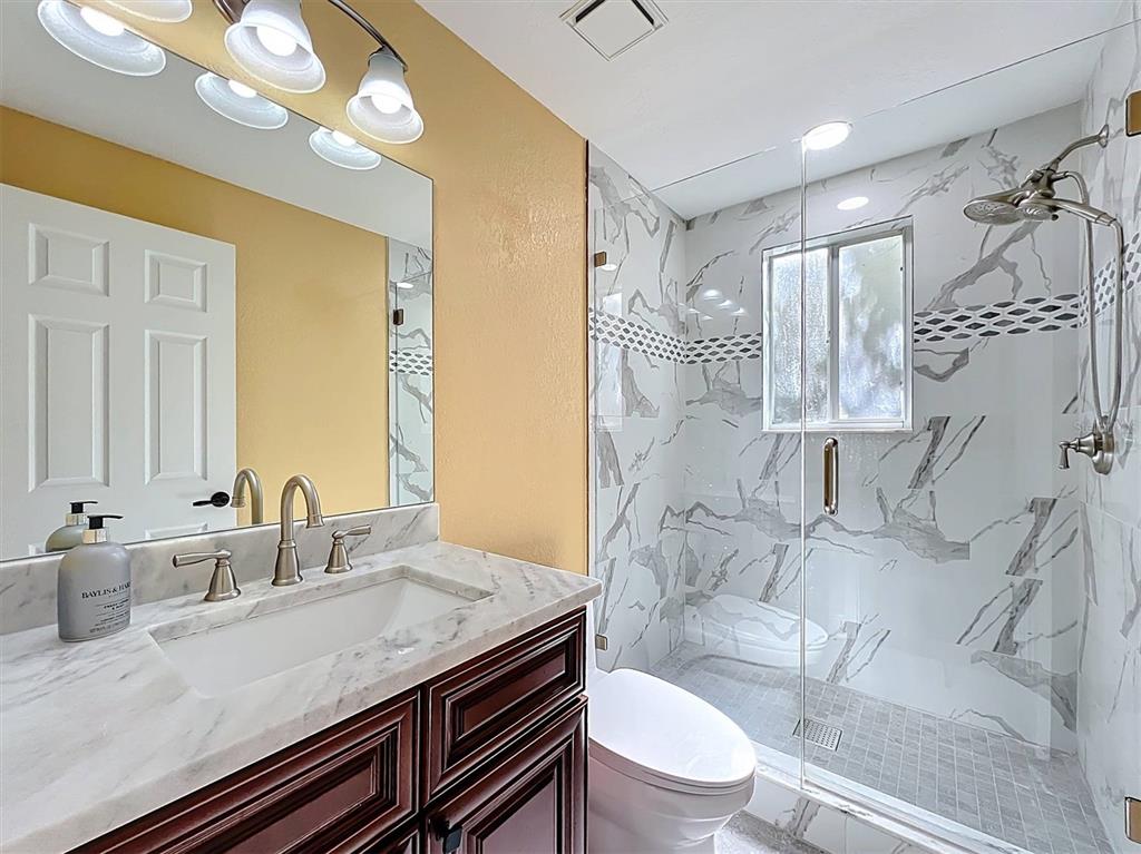 9736 Indian Key Trail, Unit 111 Seminole, FL 33776 - Photo 18 of 56 a bathroom with a granite countertop sink a toilet and shower