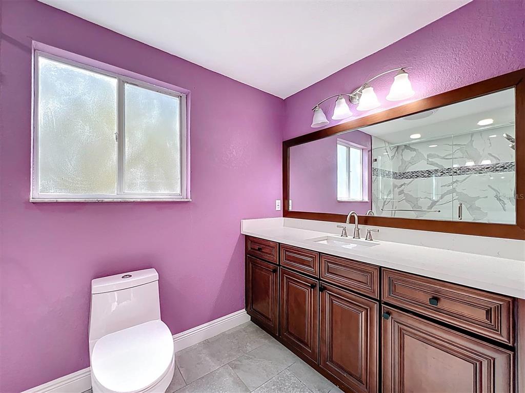 9736 Indian Key Trail, Unit 111 Seminole, FL 33776 - Photo 28 of 56 a bathroom with a toilet sink and mirror