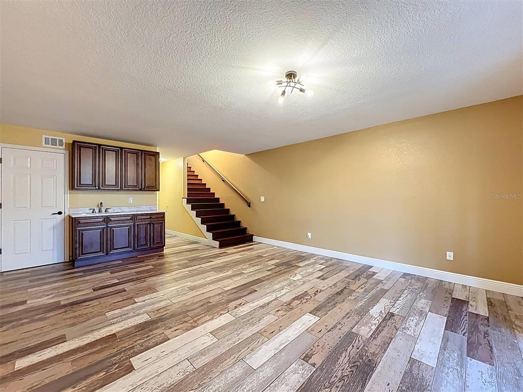 9736 Indian Key Trail, Unit 111 Seminole, FL 33776 - Photo 4 of 56 a view of a livingroom with wooden floor and stairs