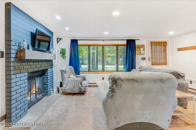 a living room with furniture a flat screen tv and a fireplace