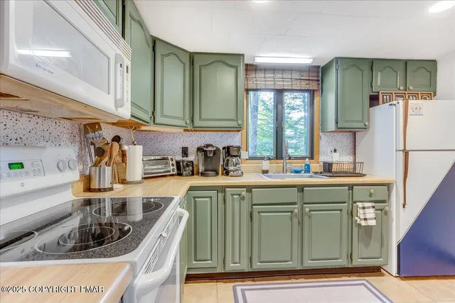 a kitchen with kitchen island a sink appliances and cabinets
