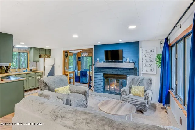 a living room with furniture large windows and a fireplace