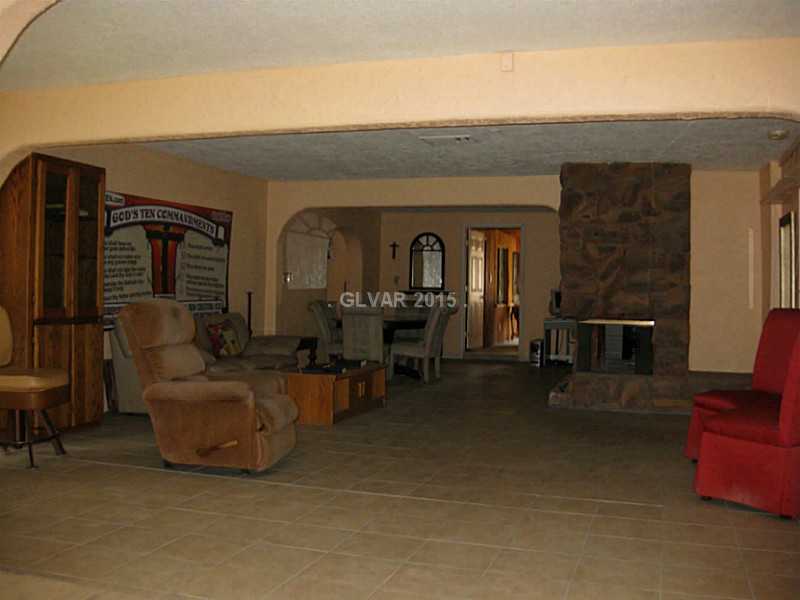 Living Room. view of living room from front door with stone fireplace and optional dining space in the rear