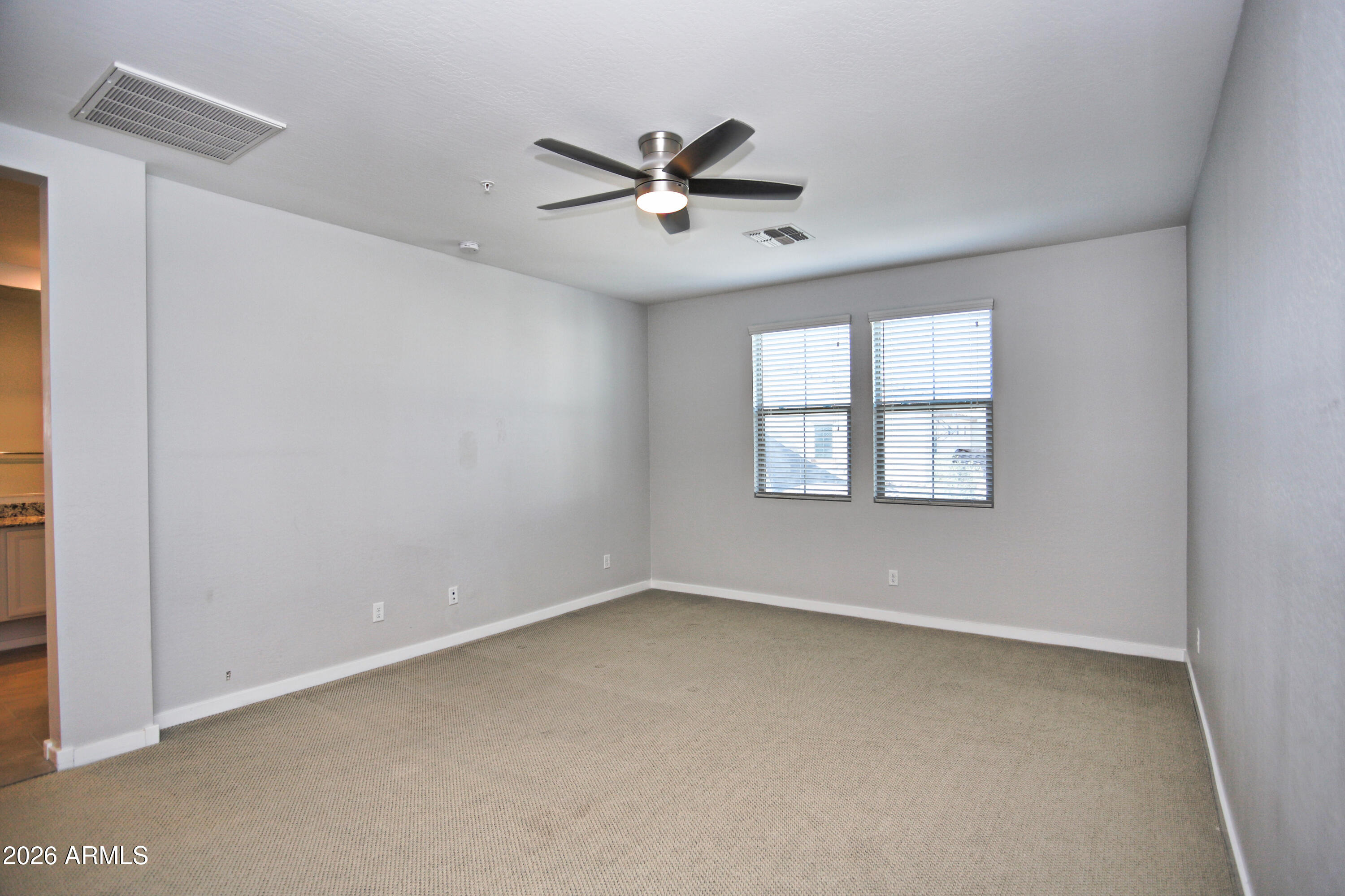 3855 South McQueen Road, Unit 110 Chandler, AZ 85286 - Photo 15 of 37 an empty room with windows and fan