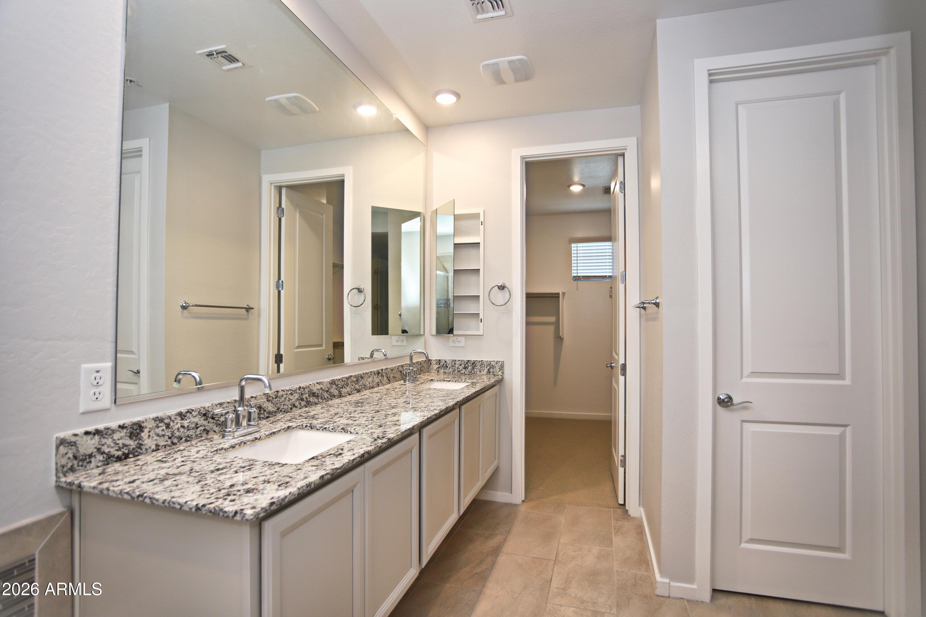 3855 South McQueen Road, Unit 110 Chandler, AZ 85286 - Photo 18 of 37 a bathroom with a granite countertop sink and a mirror