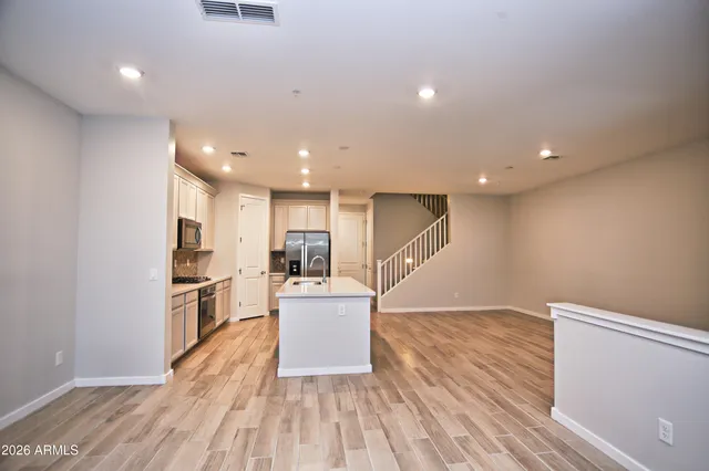 a view of kitchen with cabinets stainless steel appliances and wooden floor