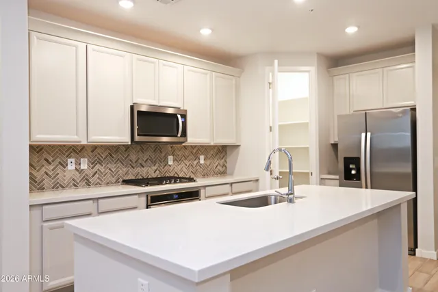 a kitchen with stainless steel appliances a microwave a sink and a refrigerator