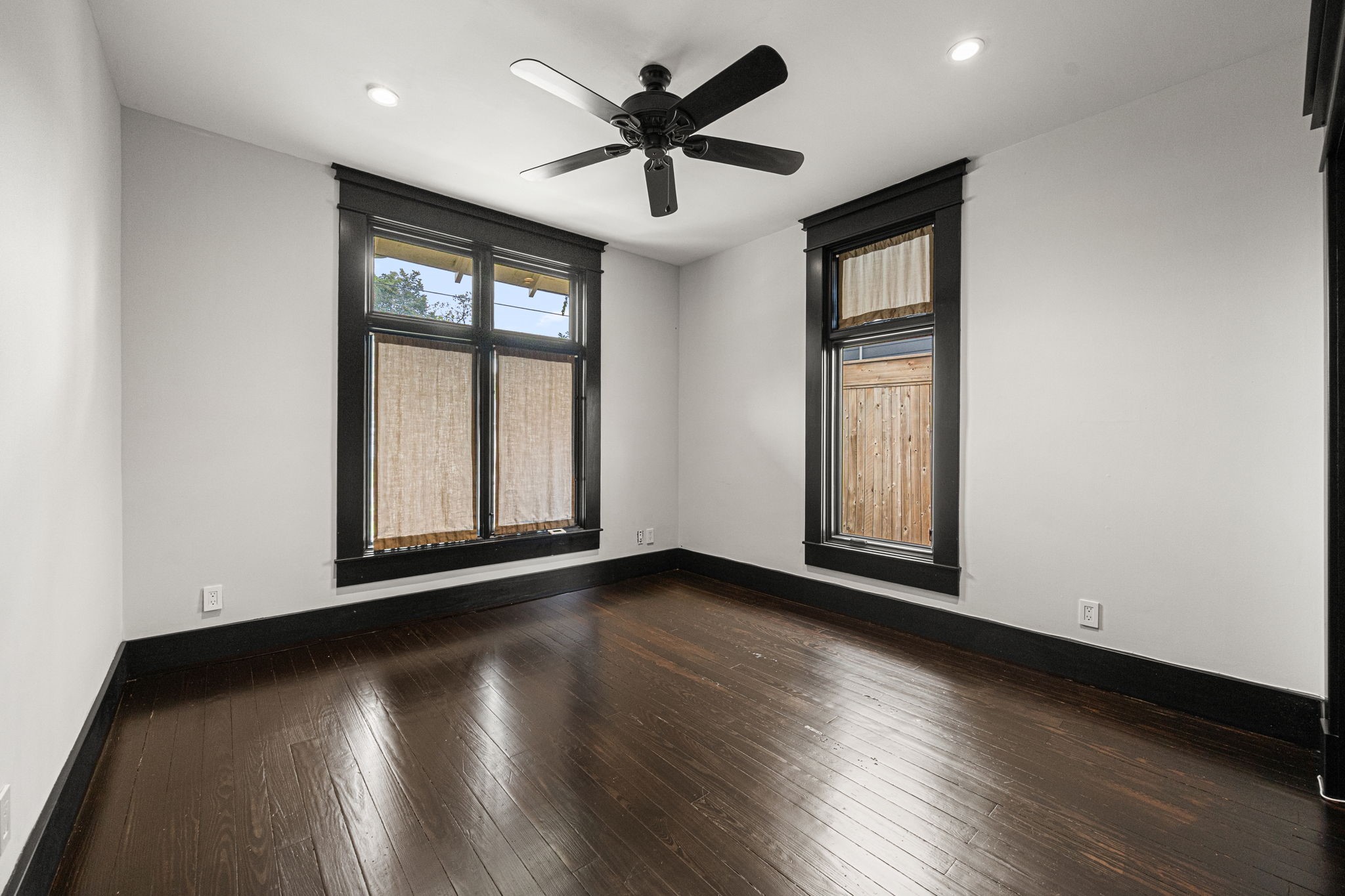1115 Adele Street Houston, TX 77009 - Photo 11 of 19 Bright secondary bedroom with hardwood floors, ceiling fan, and large windows.