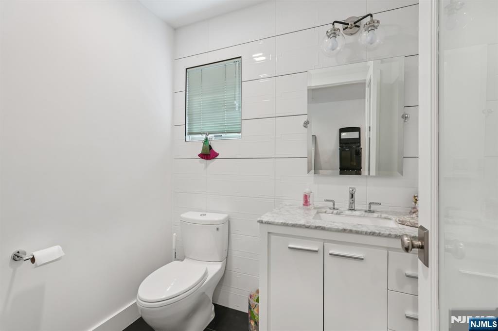 746 Undercliff Avenue, Unit A Edgewater, NJ 07020 - Photo 26 of 44 a bathroom with a toilet sink vanity and mirror