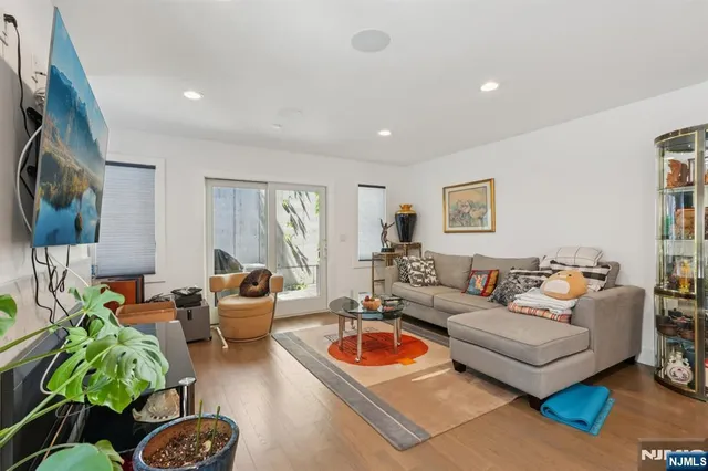 a living room with furniture a flat screen tv and a window