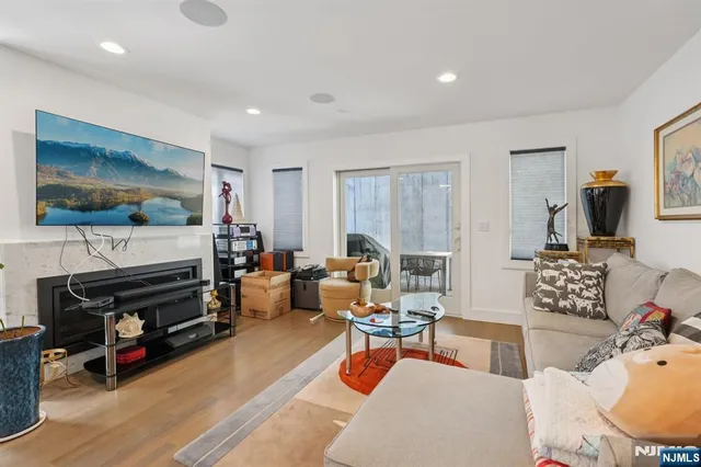 a kitchen with stainless steel appliances a refrigerator a sink dishwasher and a dining table with wooden floor