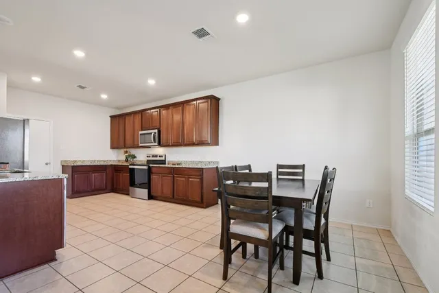 a kitchen with a table chairs microwave and cabinets
