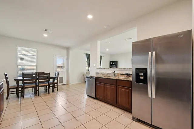 a kitchen with stainless steel appliances granite countertop a refrigerator and a sink