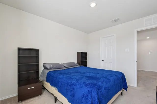 a spacious bedroom with a bed and a window