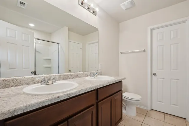 a bathroom with a granite countertop sink a mirror and a toilet