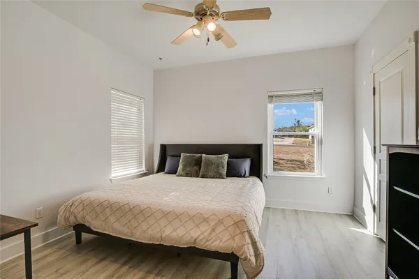 a bedroom with a large bed a chandelier and a window