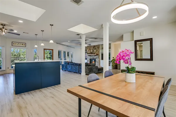 a kitchen with stainless steel appliances kitchen island granite countertop a table chairs and a refrigerator