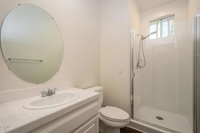 a bathroom with a granite countertop sink mirror toilet and shower