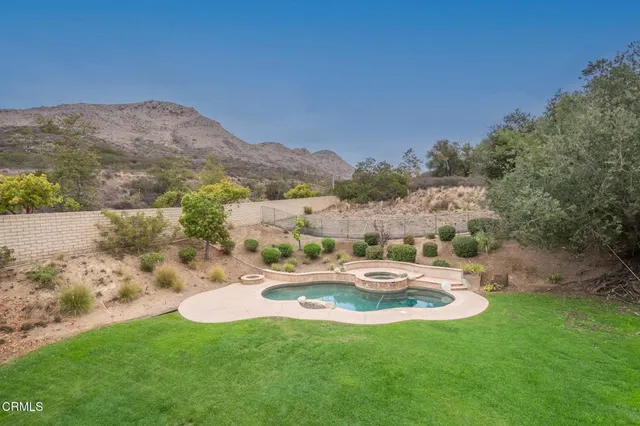 a view of a backyard with table and chairs and wooden fence
