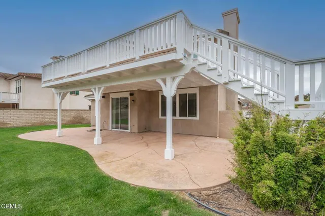 a view of a white house in front of a big yard