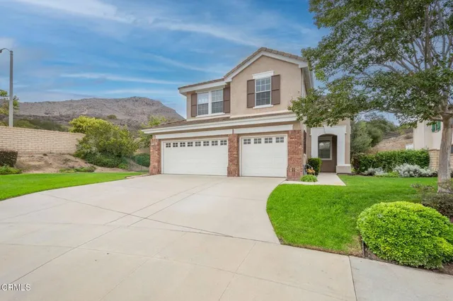 a view of a house with a yard and a garage