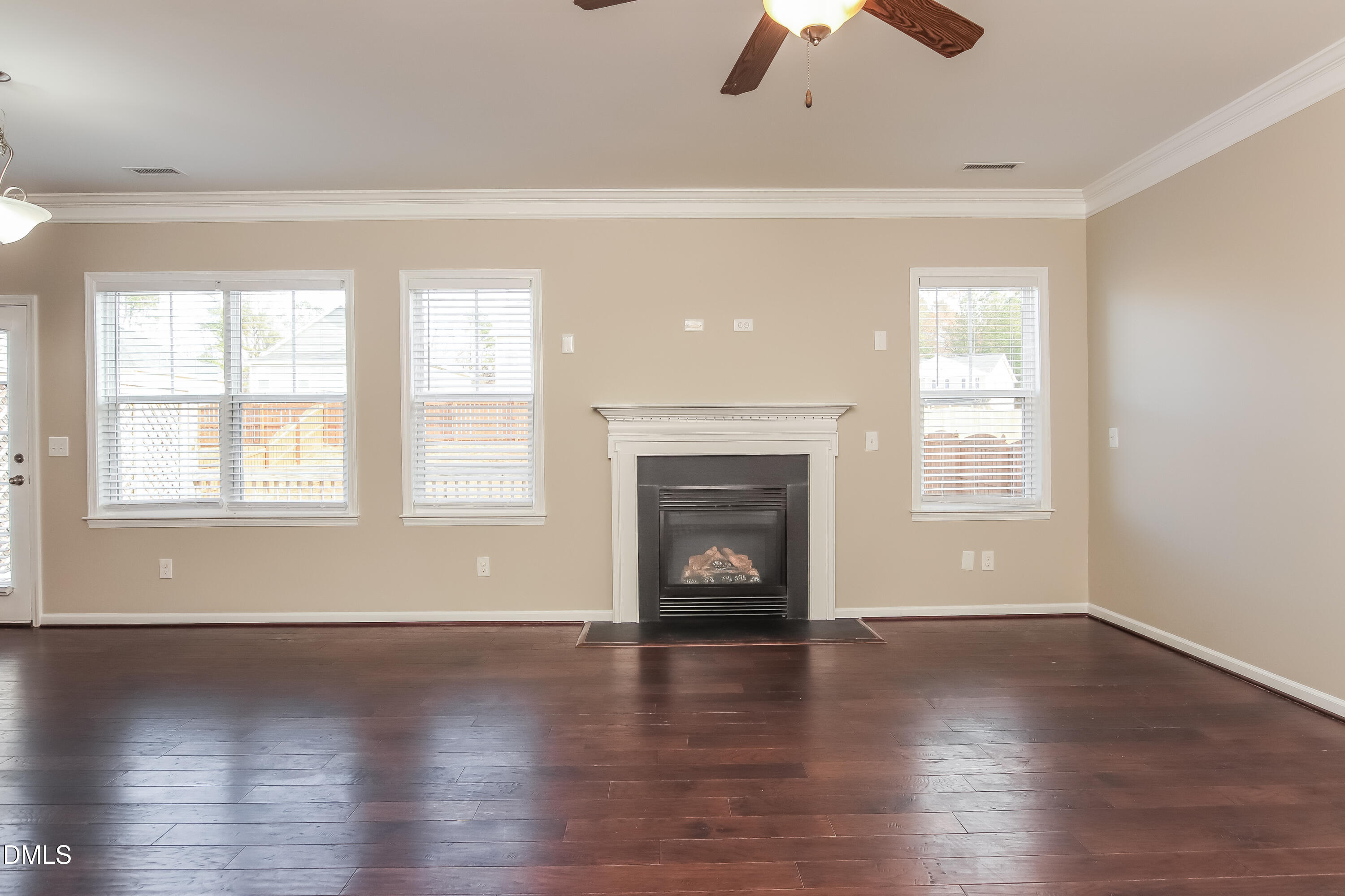1237 Barnford Mill Road Wake Forest, NC 27587 - Photo 4 of 17 an empty room with windows a fireplace and wooden floor