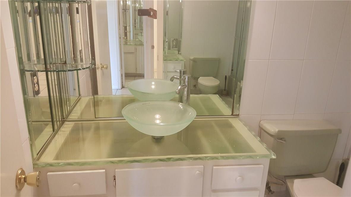3591 Inverrary Drive, Unit 406 Lauderhill, FL 33319 - Photo 10 of 12 a bathroom with a granite countertop sink and a mirror