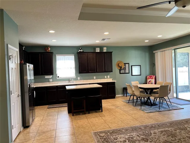 a large kitchen with kitchen island a sink table and chairs