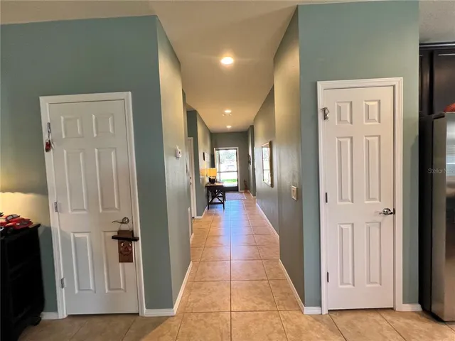 a view of a hallway with wooden floor and a living room