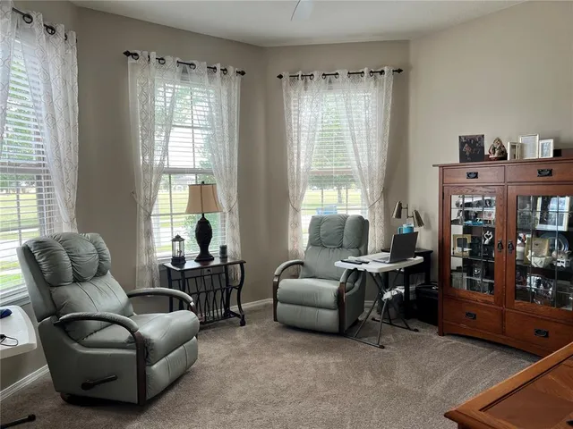 a living room with furniture and two windows
