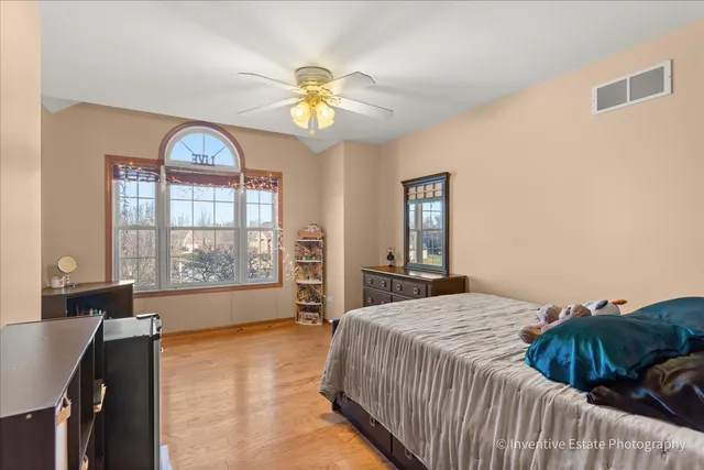 a spacious bedroom with a bed and a chandelier