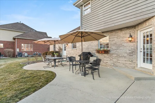 a view of a patio with chairs and table under an umbrella
