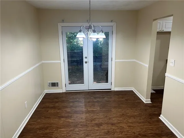 a view of a room with wooden floor and entryway