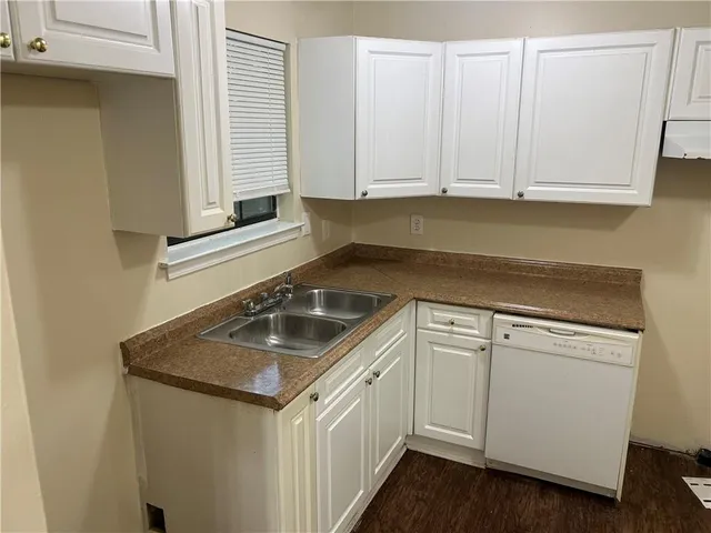 a kitchen with granite countertop white cabinets and sink